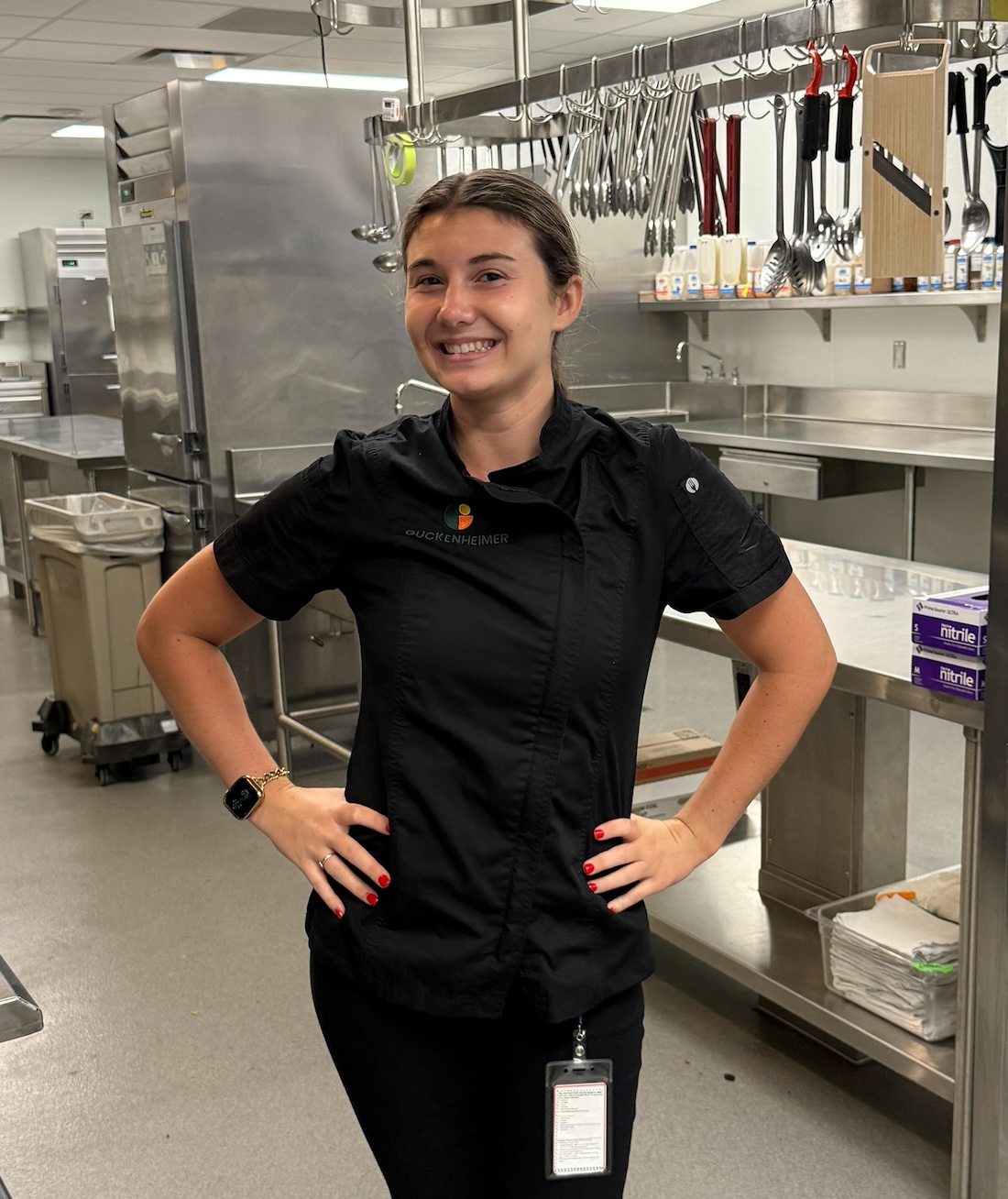 An intern standing and smiling in a kitchen
