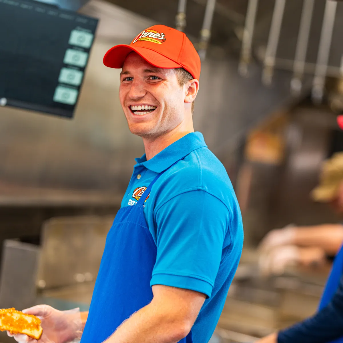A male employee at Raising Cane's laughing