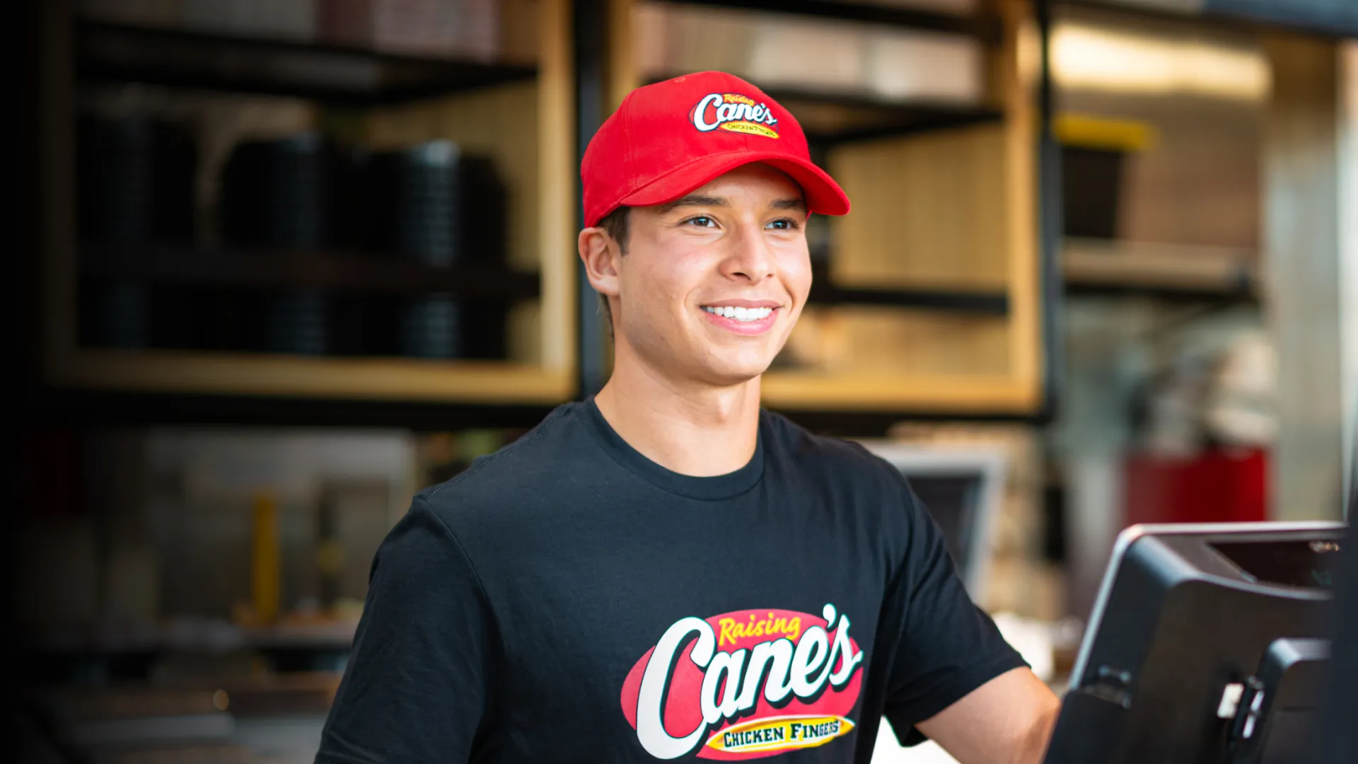 A male employee at Raising Cane's smiling