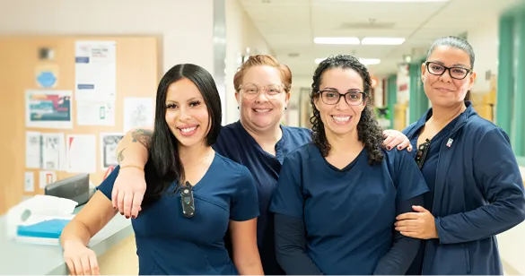 Smiling healthcare team members standing together in a clinic hallway