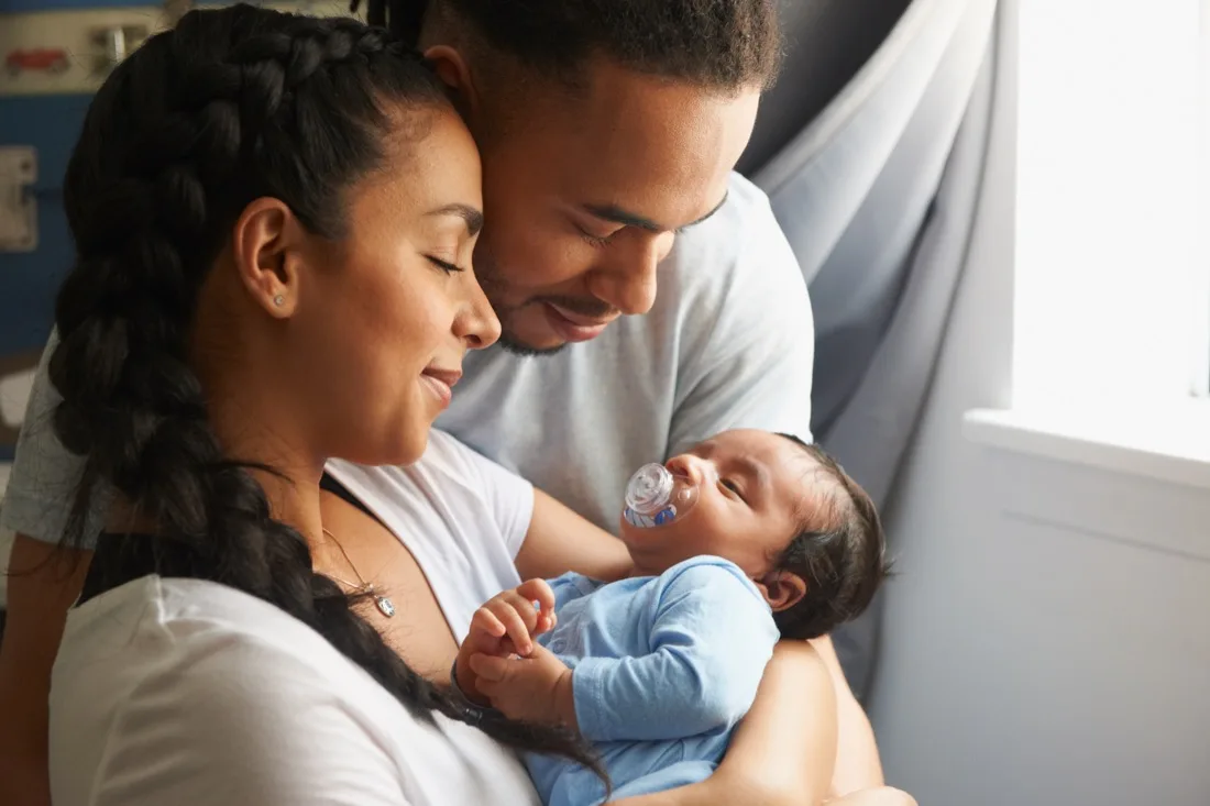 Parents holding their newborn baby at home
