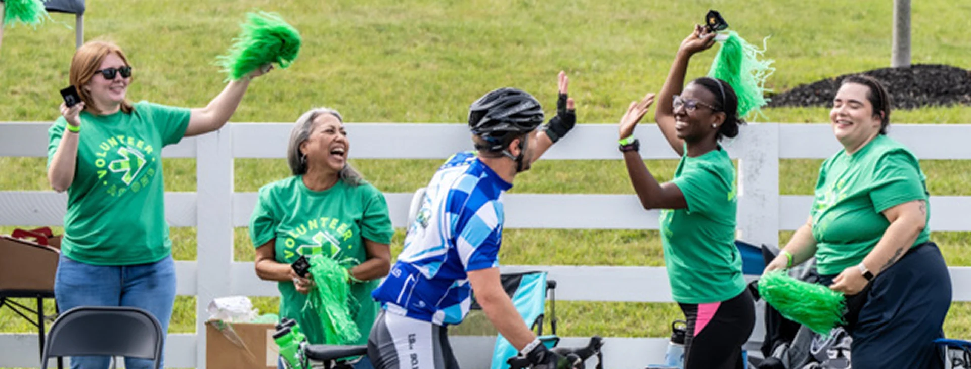 Bath & Body Works associates laughing and cheering on biciclysts in a race